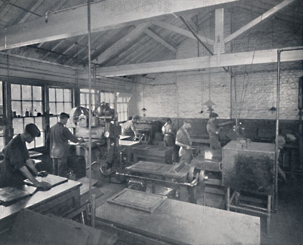 'At Work in the Foundry. Making Wax Moulds of the Pages', 1917. Artist: Unknown.