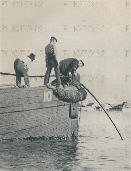 'Shore End of a submarine cable is generally laid from a lighter', 1937. Artist: Unknown.