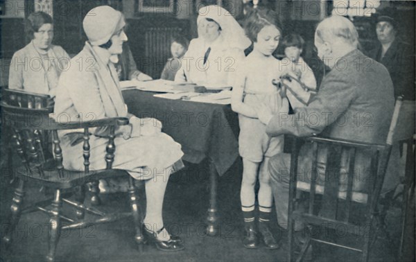 'The Doctor listening to a child's heart beat', c1935. Artist: Unknown.