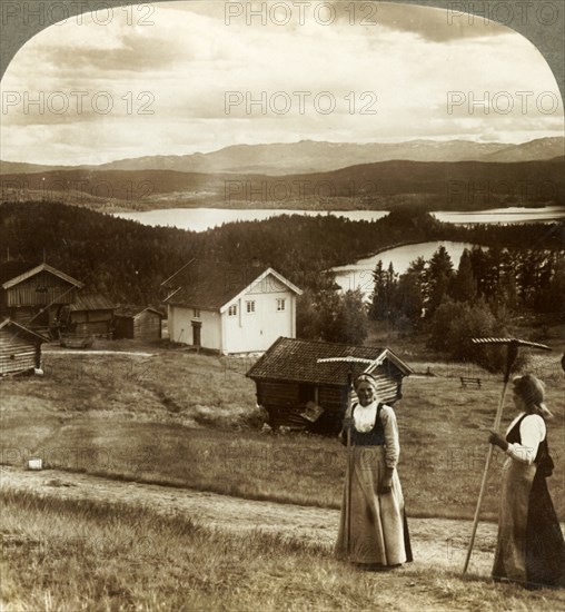 'Country girls in haying time - over Bolkesjo and Folsjo (lakes) to Himingen Mts., Norway', c1905.  Creator: Unknown.