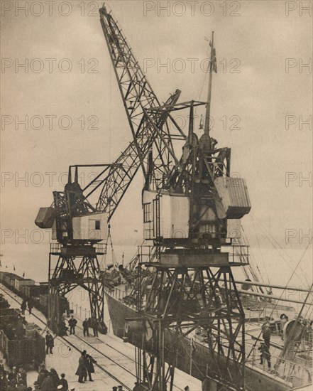 'Huge Mobile Cranes at Tilbury Swing the Cargo from a Vessel's Hold', c1935. Creator: Unknown.