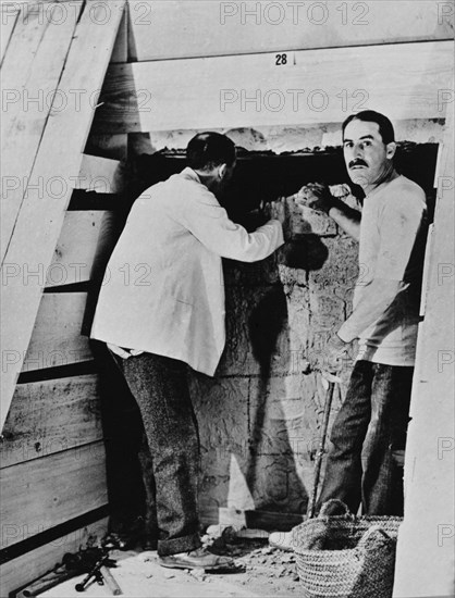 Howard Carter and a colleague excavating a tomb in the Valley of the Kings, Egypt, 1922. Artist: Harry Burton