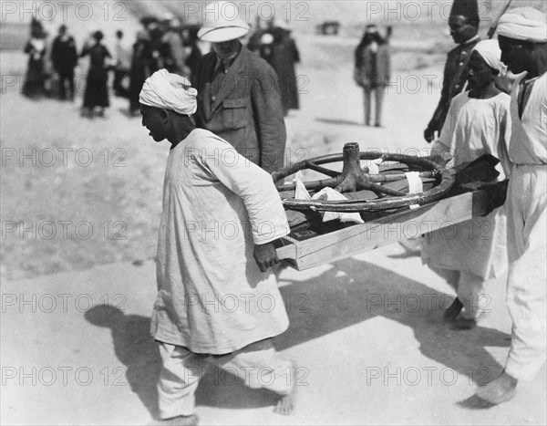 Removing a chariot wheel from the Tomb of Tutankhamun, Valley of the Kings, Egypt, 1922. Artist: Harry Burton