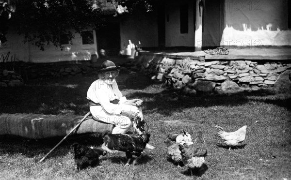 Old man feeding chickens, Bistrita Valley, Moldavia, north-east Romania, c1920-c1945. Artist: Adolph Chevalier