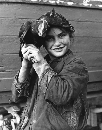 Gipsy girl holding a chicken, 1960s.