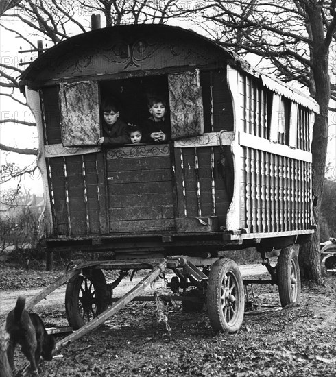 Gipsy children looking out of their caravan by the roadside, Charlwood, Surrey, 1964.