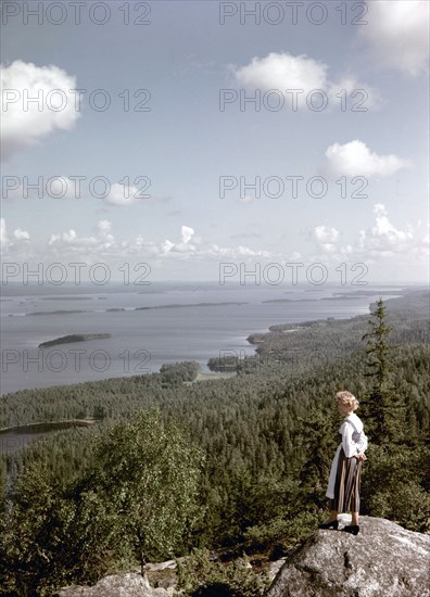 A young woman in traditional dresslooking out over Lake Pielinen, Koli district, Finland, 1960s. Artist: Göran Algård