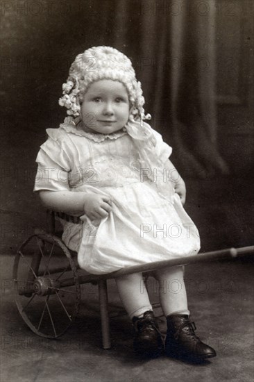 A little girl in a cart, c1910. Artist: Unknown