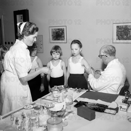 A doctor and his nurse vaccinate schoolgirls againgst polio, Landskrona, Sweden, 1957. Artist: Unknown