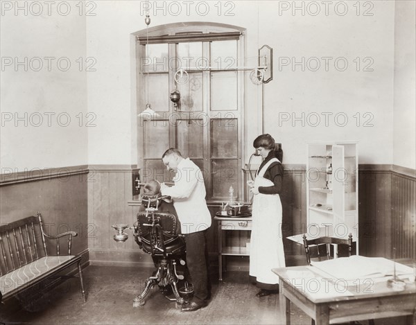 A dentist and his nurse give a schoolboy his treatment, 1910s. Artist: Unknown