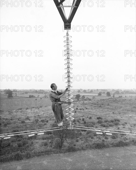 Electricity power insulator, cables and worker up a pylon, Nottinghamshire,c1950s-1960s(?). Artist: CEGB