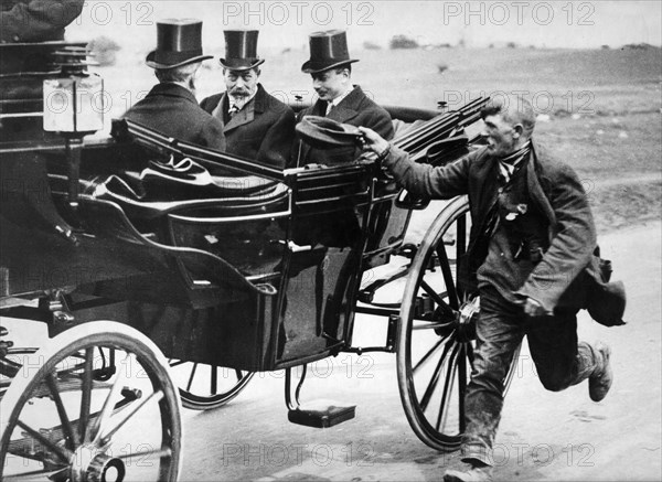 Beggar holidng out his cap as he passes King George V in a carriage, c1911-1936. Artist: Unknown