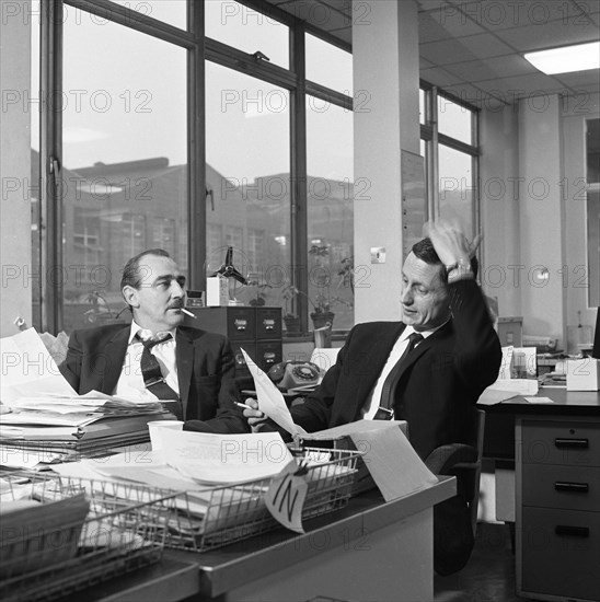 Lost order? two salesmen try to sort out the orders over a cigarette, 1967. Artist: Michael Walters