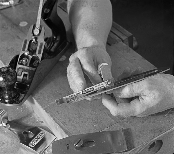 Using an adjustment gauge on a Stanley plane, 1968. Artist: Michael Walters