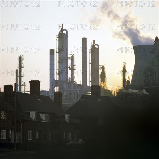 A petrochemical plant towering over residential housing, Baglan Bay, Wales, 1975. Artist: Michael Walters