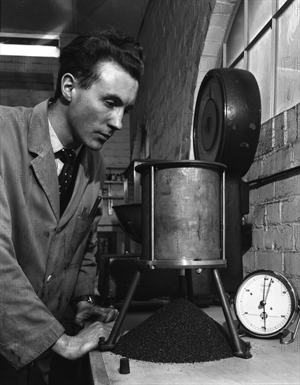 A lab technician undertaking a coal flow test, Mapperley Colliery, Derbyshire, 1962.  Artist: Michael Walters