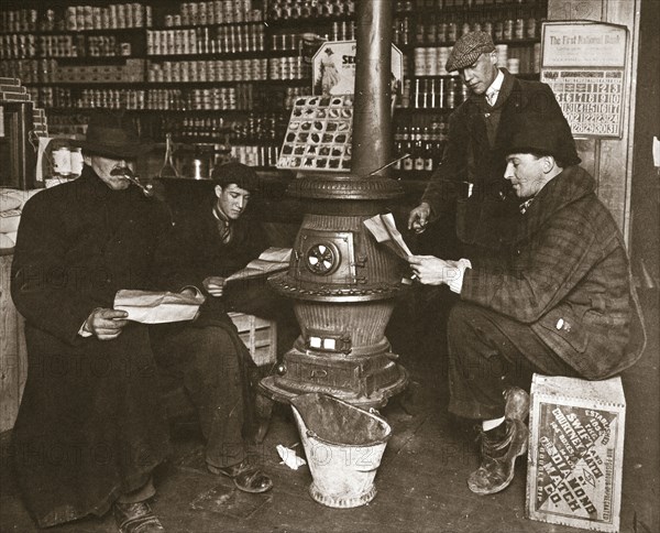 A group of men around a stove in a shop, USA, c1910. Artist: Unknown