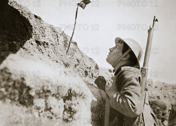 A sentry in the trenches looking through an improvised persicope, France, World War I, 1916. Artist: Unknown