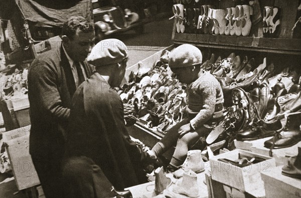 A woman from Harlem buys a pair of shoes for her child, New York, USA, c1920s-c1930s. Artist: Unknown