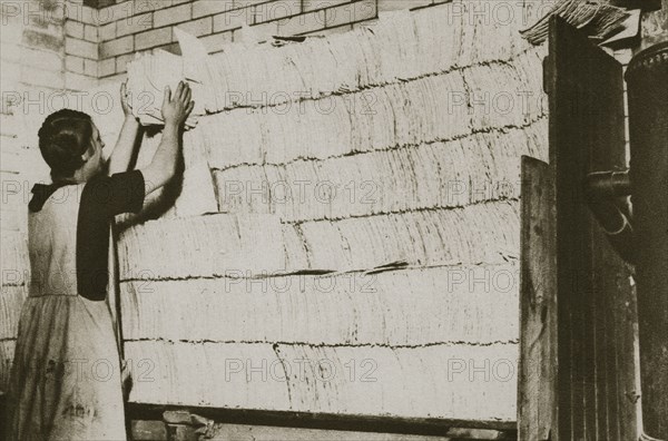 Stacking unleavened bread for the Passover in a Jewish bakery, 20th century. Artist: Unknown