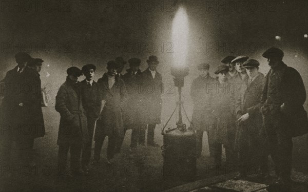 Gathering around an acetylene flare at a traffic control point in the fog, early 20th century. Artist: Unknown