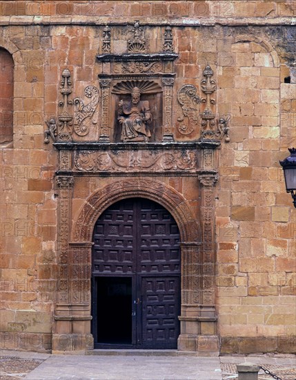 Front door of St. Peter's Cathedral, crowned by the seated image of Saint Peter Pope, embedded in?