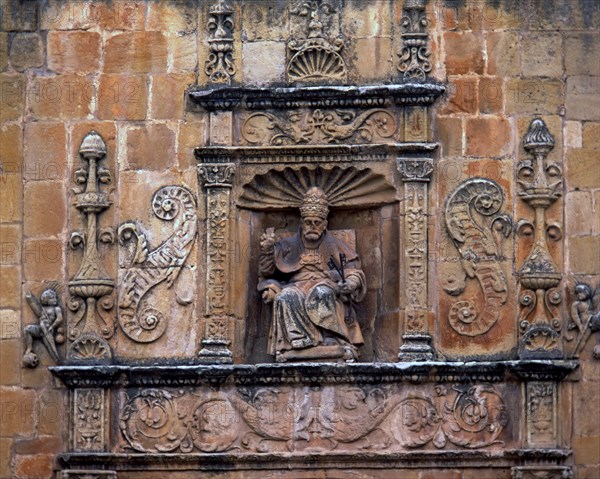 Front door of St. Peter's Cathedral, crowned by the seated image of Saint Peter Pope, embedded in?