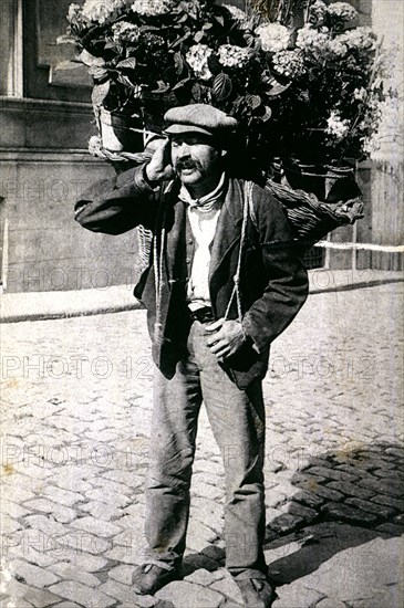 Typical picture of a street vendor of flowers, 1910.