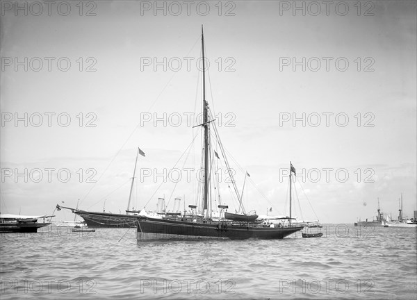 The yawl 'Beluga' at anchor, 1911. Creator: Kirk & Sons of Cowes.