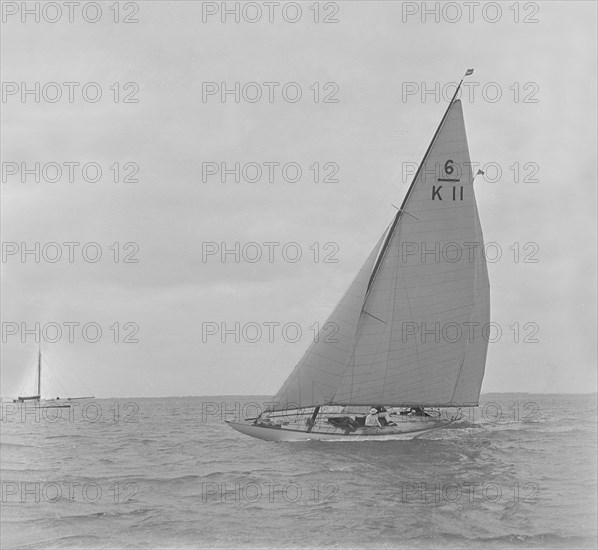 The 6 Metre class 'Freesia' sailing close-hauled, 1921. Creator: Kirk & Sons of Cowes.