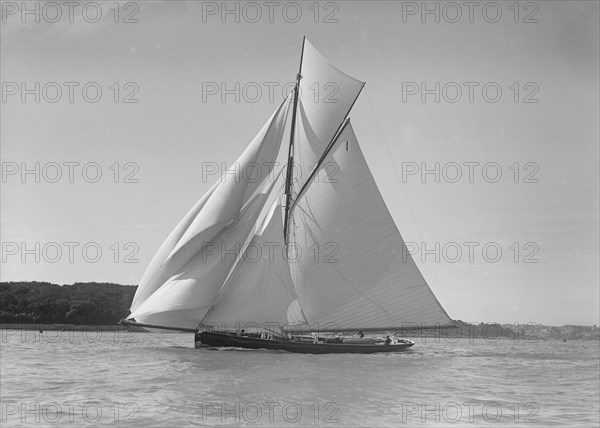 The gaff rigged cutter 'Bloodhound' sailing downwind under spinnaker, 1911. Creator: Kirk & Sons of Cowes.