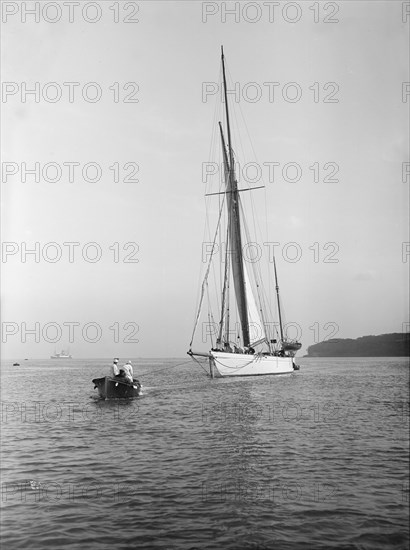 Sailing yacht 'Bona' being towed, 1912. Creator: Kirk & Sons of Cowes.