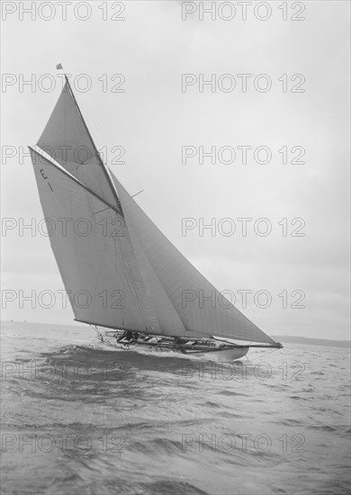 The 12 Metre yacht 'Alachie' makes swift progress upwind, 1911. Creator: Kirk & Sons of Cowes.