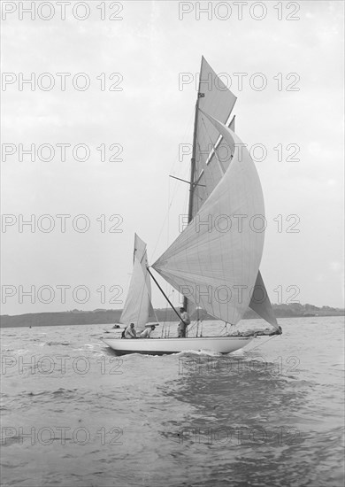 The 8-metre 'Ierne' sailing with spinnaker, 1913. Creator: Kirk & Sons of Cowes.