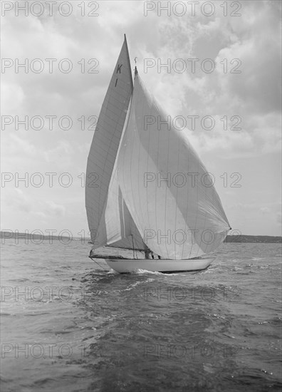 The 7 Metre 'Marsinah' (K1) sailing with spinnaker, 1912. Creator: Kirk & Sons of Cowes.