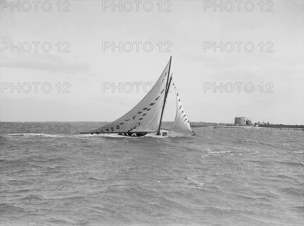 The 7 Metre 'Ginerva' (K7) under sail with prize flags, 1912. Creator: Kirk & Sons of Cowes.