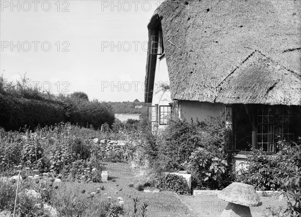 Thatched cottage and garden, c1935. Creator: Kirk & Sons of Cowes.