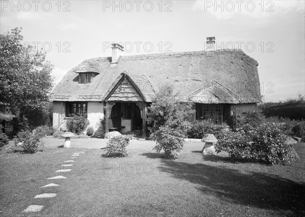 Thatched cottage and garden, c1935. Creator: Kirk & Sons of Cowes.