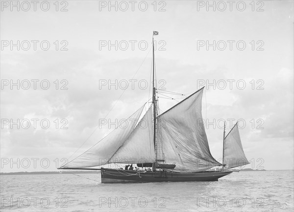 The yawl 'Roma' raising main sail, 1912. Creator: Kirk & Sons of Cowes.