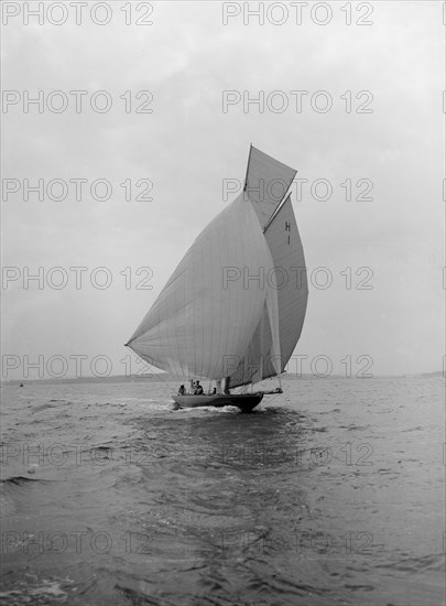 The 8 Metre class 'Antwerpia IV' sailing under spinnaker, 1912. Creator: Kirk & Sons of Cowes.