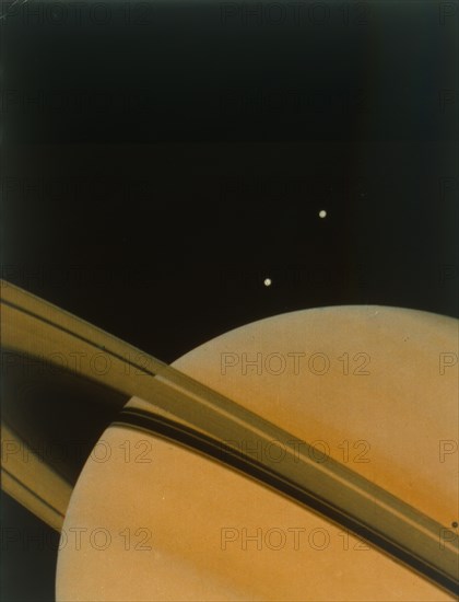 The planet Saturn with moons Tethys and Dione. Creator: NASA.