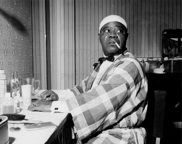 Louis Armstrong relaxing backstage, Finsbury Park Astoria, London, 1962.