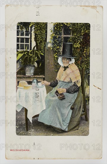 A Welsh woman at tea table with knitting on her lap, c1900.