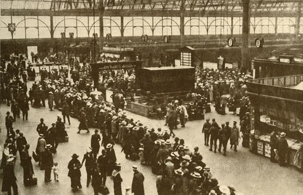 A Queue of Holiday-Makers Waiting for Trains at Waterloo Station, London', 1930.