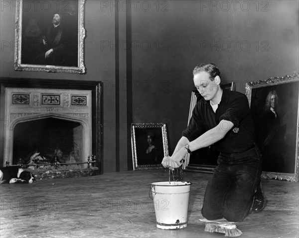 Edward, Lord Montagu of Beaulieu scrubbing floors in Palace House 1952. Creator: Unknown.