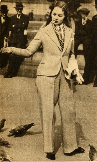 'A betrousered lady feeding pigeons in Trafalgar Square', 1933. Creator: Unknown.