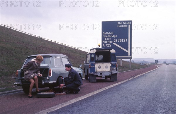 Austin A40 Farina having wheel changed by R.A.C breakdown assistance. Creator: Unknown.