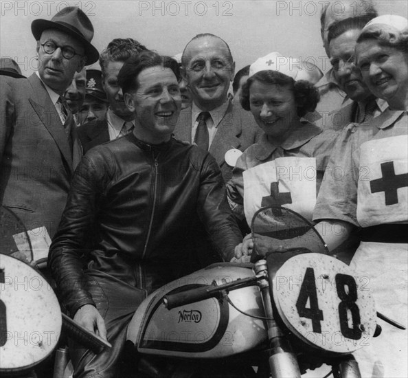 Geoff Duke on Norton, with nurses after race in 1951. Creator: Unknown.