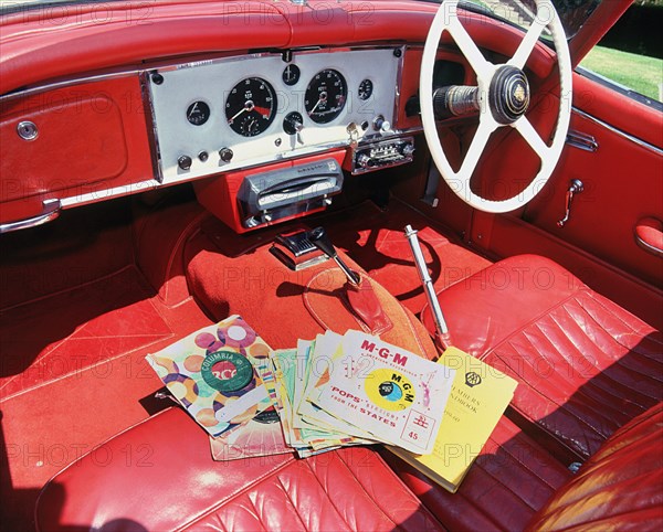1960 Jaguar XK150 interior with record player and 7inch vinyl discs.. Creator: Unknown.
