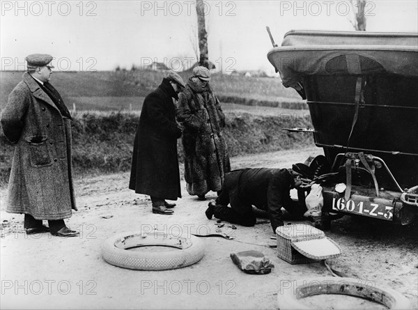 Wheel change by chauffeur on Lord Northcliffe's 1908 Mercedes. Creator: Unknown.